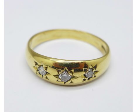 An 18ct gold, three stone diamond ring, 6.1g, X 