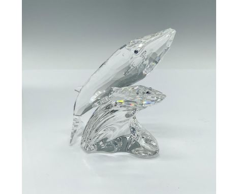 Brilliantly crafted from clear crystal, this figure depicts a mother and baby whale swimming gracefully atop a clear wave. Be