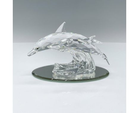 Crafted from clear crystal, these dolphins gracefully swim atop a faceted crystal wave, capturing the beauty of a mother dolp