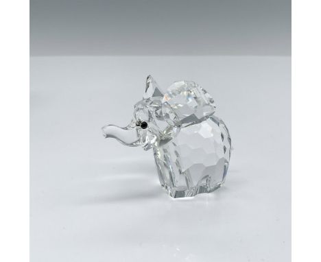 A clear faceted elephant with its ears out, trunk up, frosted tail, and black crystal eyes. This item has its original box wh