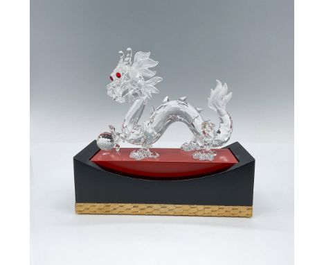 A magnificent Swarovski crystal figurine depicting a Chinese dragon gripping an orb in its right foot. Crafted with meticulou