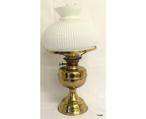 A brass based oil lamp and globe