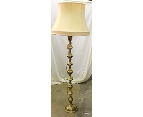 A brass and enamel standard lamp with shade with a bulbous turned shape