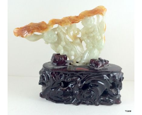A Jade carving on carved wood base
