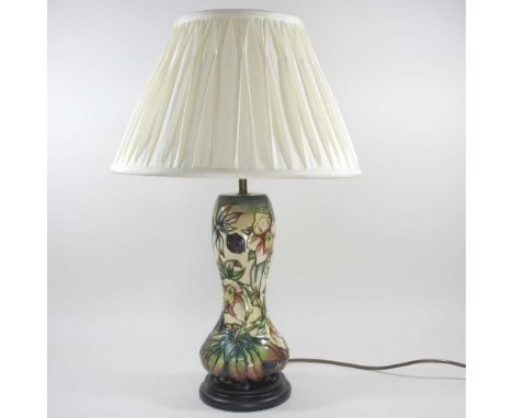 A Moorcroft pottery table lamp, decorated in the Hellebore pattern, by Nicola Slaney, with a cream shade, 57cm high overallOv