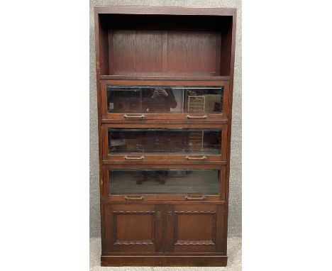 A vintage oak bookcase with glazed and bevelled lift up sections over panelled doors. H.211 W.106 D.40cm 