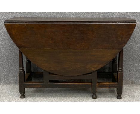 An 18th century country oak drop flap dining table fitted with frieze drawer and with gate-leg action. H.69 W.38cm L.111cm (1