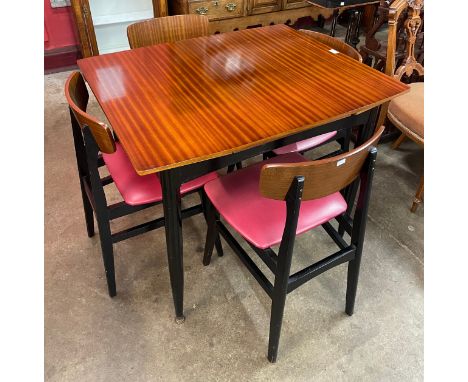 A Harris Lebus tola wood and black extending dining table and four chairs