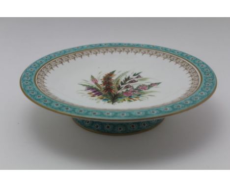 A MID TO LATE 19TH CENTURY ROYAL WORCESTER PORCELAIN LOW COMPORT, gilded turquoise the centre hand painted with a floral disp