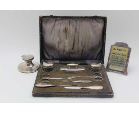 A MANICURE CASE contains a quantity of silver mounted requisites, the nail buffer is hallmarked Birmingham 1921, together wit