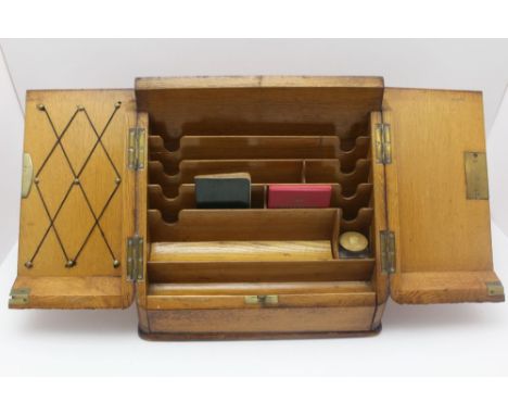 A VICTORIAN OAK SLOPE FRONT WRITING &amp; STATIONARY BOX, the two doors open to reveal a fitted interior, pen tray and inkwel