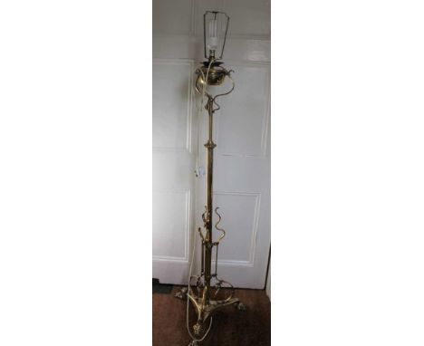 A PROBABLE EARLY 20TH CENTURY ADJUSTABLE BRASS STANDARD LIGHT FITTING, supported on cast claw feet, now converted to electric