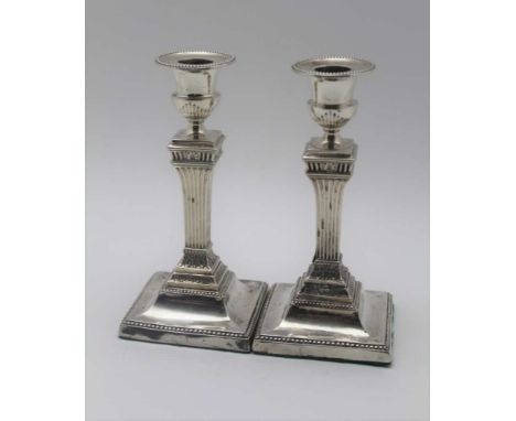 HARRISON BROTHERS & HOWSON A pair of late Victorian silver candlesticks, of classical column design, bead edged sconces & squ