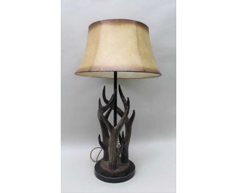 A NOVELTY TABLE LAMP IN THE FORM OF DEER ANTLERS, with parchment effect shade, 62cm high to light fitting 