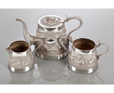 INDIAN WHITE METAL THREE PIECE TEA SERVICE
comprising tea pot, sugar and cream, with hunting animal scenes in relief, the tea