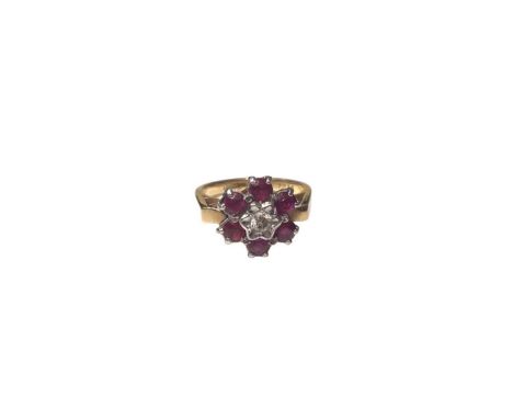 18ct gold ruby and diamond flower head cluster ring with a central brilliant cut diamond surrounded by six round mixed cut ru