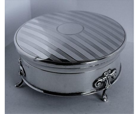 A Victorian silver circular trinket box with engine turned decoration to hinged lid, lined and gilded interior raised on thre