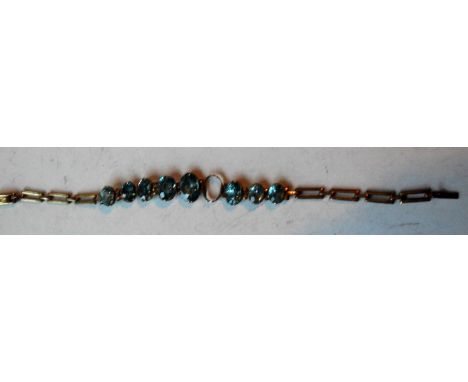A yellow metal gate-link bracelet with graduated oval topaz-coloured stones (one missing), 16 cm long, gross weight 5.63 g 