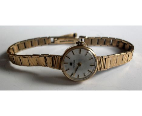 A 9ct gold Tissot lady's watch with circular silvered dial, gold hands, baton indices on a bracelet strap and clasp, in worki