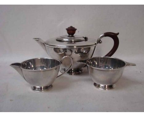 An Art Deco silver three piece Bachelor Tea Service by Henry Clifford Davis, Birmingham 1942, teapot with composition finial 