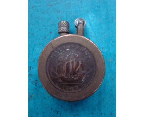 A trench art cigarette lighter embellished with British half penny coins, dated 1943