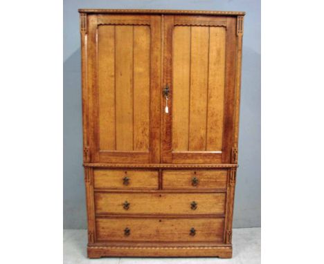 A late 19th century Arts and Crafts golden oak press cupboard, possibly by Talbot, the upper portion with inlaid carved detai