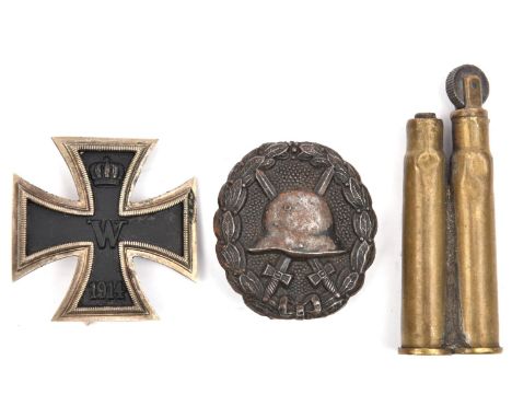 A 1914 Iron Cross 1st class, of light weight construction with ferrous centre; a WWI black wound badge; and a WWII trench art