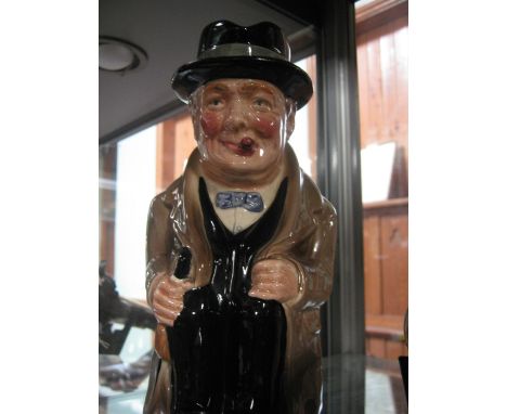 A Royal Doulton Toby jug "Winston Churchill", seated, smoking his habitual cigar, in evening dress, grey cloak and Homberg ha
