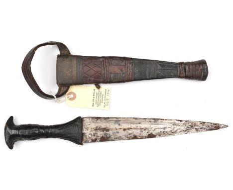 A Sudanese arm dagger,  tapering blade 9" with simple incised panels, leather covered hilt and sheath with arm loop, incised 