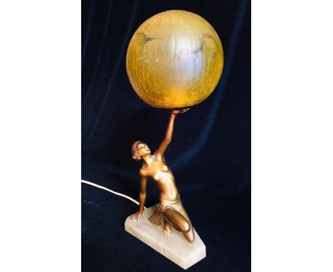 An Art Deco Lamp with a figure of a lady holding a crackle glass globe shade.