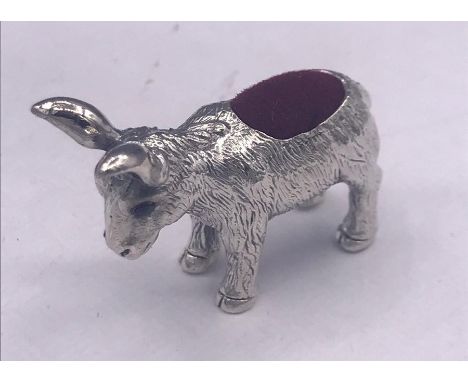 A silver pincushion in form of a donkey with ruby eyes