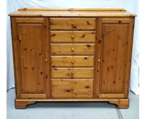 DUCAL WAXED PINE DRESSING CHESTwith a shaped raised back above a moulded top with six central drawers flanked by a pair of pa