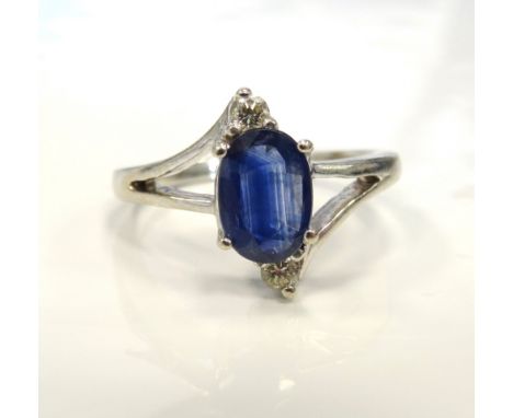 SAPPHIRE AND DIAMOND DRESS RINGthe oval cut sapphire with a diamond above and below, on nine carat white gold shank with deco