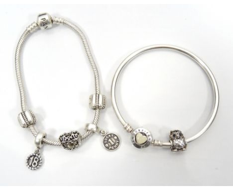 TWO PANDORA BRACELETS WITH CHARMScomprising a Loving Hearts Clasp silver bangle with one charm; and a Pandora Moments silver 