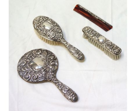 ELIZABETH II SILVER DRESSING TABLE SETcomprising a hand mirror, comb and two brushes, all with embossed decoration, Birmingha