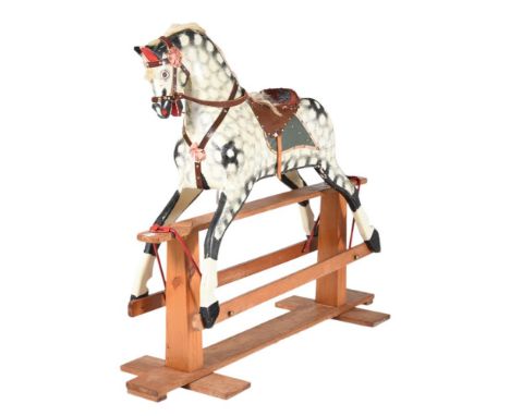 A DAPPLED GREY ROCKING HORSE20TH CENTURYMounted with tack, on rocker base118cm high, the base 130cm long, 45cm wideProvenance