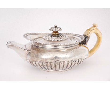 George IV silver teapot. An early 19th century silver teapot of squat-melon form, the ivory c-shaped handle on semi-reeded bo