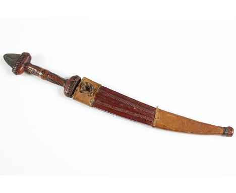 A North African Curved Dagger; single blade (fullered) approx 17.5 cms, handle approx 11 cms, in a leather scabbard with deco