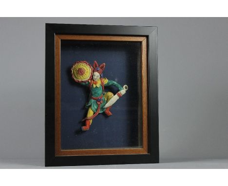 A Ceramic Chinese Theatre Actor, in an aggressive pose, with a sword and shield, housed in a box frame measuring approx 30 x 