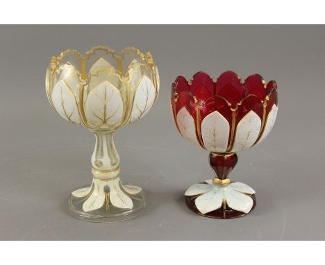 Two glass and enamel goblet vases; the first being a Cranberry glass vase with leaf-shaped bowl and leaf decoration to stem a