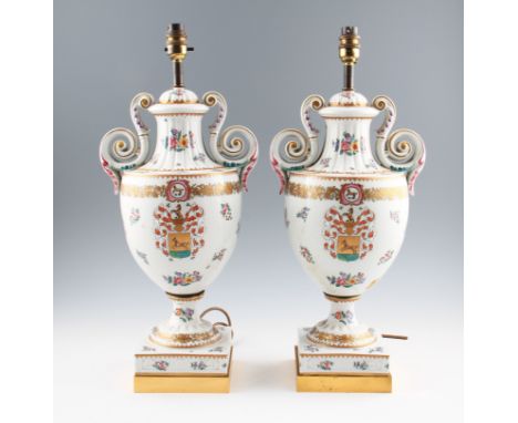 A pair of late 20th Century Continental ceramic lamp bases with floral decoration and crest to front.