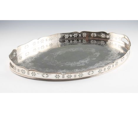 A Victorian silver gallery tray, of oval form engraved with two rows of concentric scroll and foliage design, with pierced de