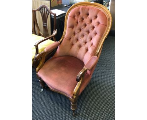A Victorian mahogany arm chair with red button backed upholstery.