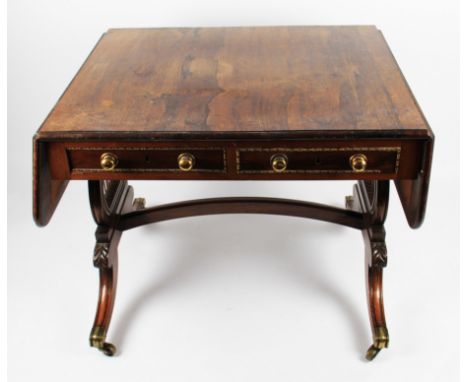 A 19th Century Regency rosewood drop leaf sofa table with two drawers and two false drawers on lyre shaped supports with dome