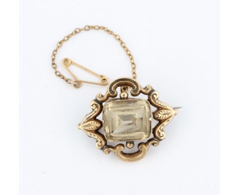 A Victorian citrine brooch, set with a central cushion cut citrine surrounded by open metalwork scroll design, set in unmarke