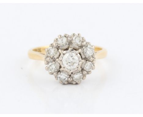 A diamond tier ring, set with a central round cut diamond surrounded by a further four smaller round cut diamonds, stamped 18