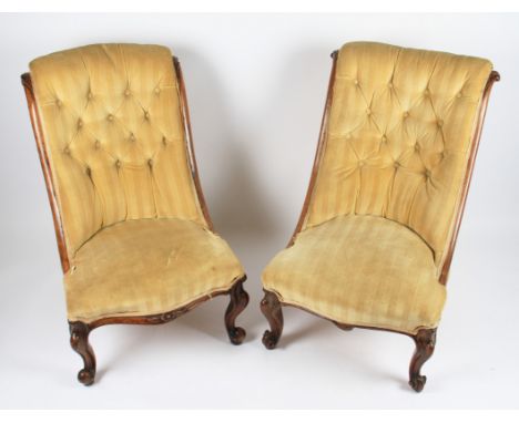 A pair of 19th Century carved walnut framed nursing chairs with beige button backed upholstery, height 82cm.