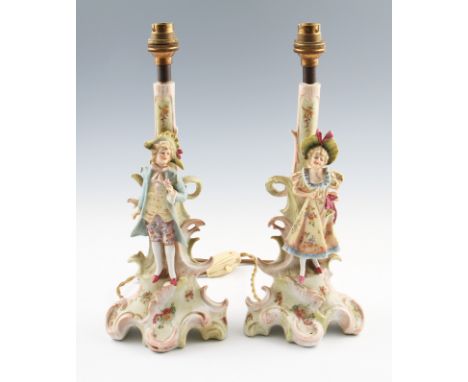 A pair of early 20th Century Continental lamp bases, each having figures to front in classical dress.