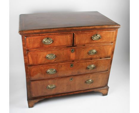 An 18th Century walnut chest of two over three graduating drawers, each having patterned brass drop handles, the walnut top h