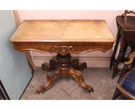 A mid Victorian walnut card table on carved cabriole legs